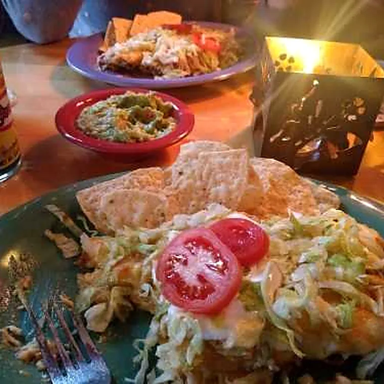 A full enchilada with chips, guacamole and salsa on the table at Mama&rsquo;s Ladas