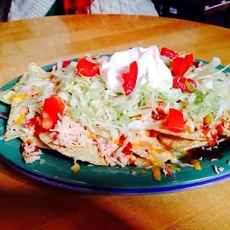 Chicken nachos with sour cream and tomato